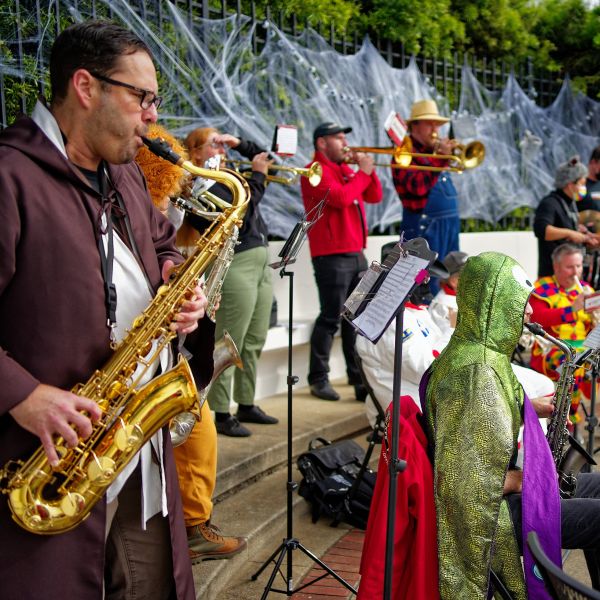 San Francisco Pride Band musicians performing outdoors in colorful Halloween costumes