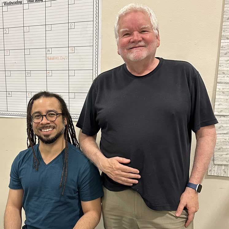 Carlos McMillan Fuentes seated with Artistic Director Pete Nowlen standing beside him.