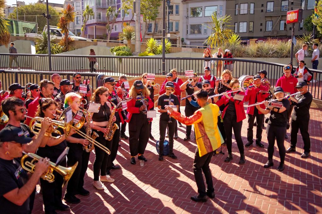 Members of the San Francisco Pride Band performing outdoors in the Castro