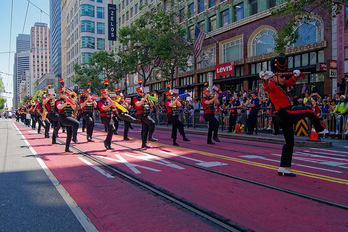 San Francisco Pride Band marches down Market Street during the SF Pride Parade, performing a kick step.